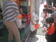 幼児さんがお菓子をバケツに入れている様子