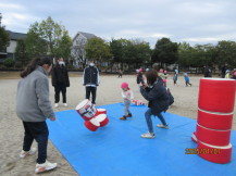 児童たちがだるま落としで遊んでいる様子