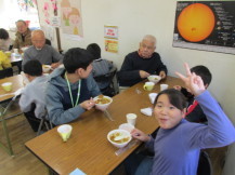 地域の方とカレーを食べている写真