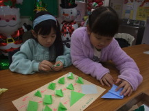 折り紙でクリスマスツリーを作っている写真