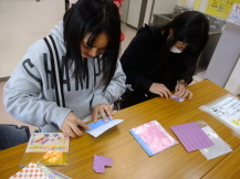 ハートの折り紙を折ってる中学生の写真
