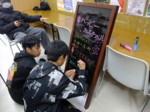中学生が看板を書いている写真