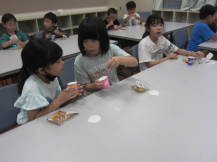 オリジナルおやつを食べる小学生の写真