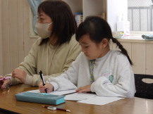 こども運営会議で出た意見をまとめている書記担当の小学生児童の写真