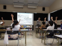 講師の説明に対し挙手をする小学生児童の写真