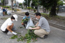 地域の人と一緒に公演のゴミ拾いをする小学生児童の写真