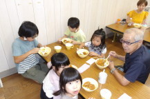 親子でテーブルを囲んでカレーを食べている写真