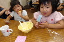 ご飯の後にデザートのアイスを食べる子どもたちの写真