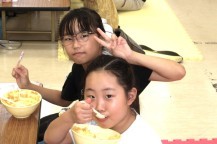 姉妹でカレーを食べながらピースサインをする女の子たちの写真