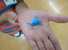 児童がおりがみで作った小さなはばたく鶴の写真