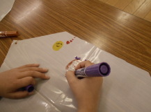 凧に絵を描いている子どもの写真