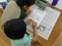 折り紙でカボチャを作っている子どもたちの写真