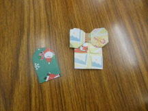 クリスマス柄の折り紙でできたお守りとプレゼントの写真