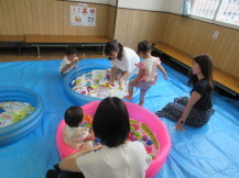 室内のビニールプールで遊んでいる様子