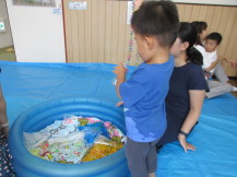 水遊び用のおもちゃで遊ぶ幼児の様子