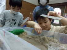 川の模型の砂を掘っている子どもたちの写真2