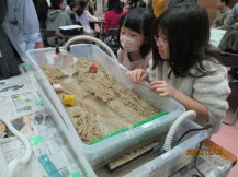 川の模型に実際に水を流している子どもたちの写真2