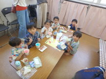 かき氷とフランクフルトを食べている子どもたちの写真1