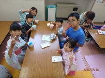 かき氷とフランクフルトを食べている子どもたちの写真2