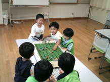 サッカー盤で遊ぶ子たち