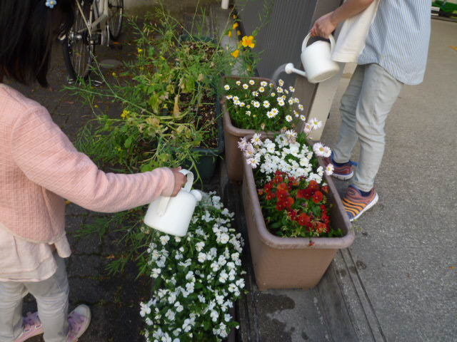 子どもたちが花に水やりをしている