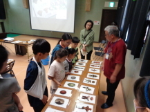 縄文土器の写真を見る子どもたちの写真