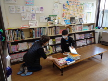 図書室を掃除する子どもとボランティアの写真
