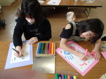 子どたちが手形に絵やイラストを書き足している写真
