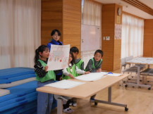 蟹ヶ谷保育園の年長さんに紙芝居を読む一年生の様子