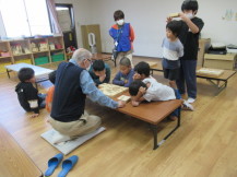 将棋を教わる子どもたちの写真