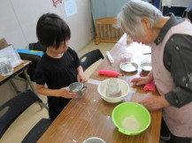 陶芸教室で素焼きの作品に色塗りをしている子ども