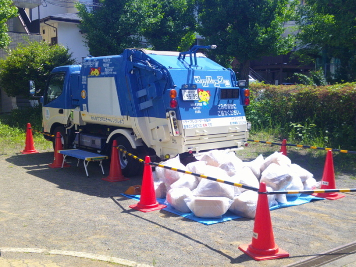 中身が見えるように、側面がアクリル板になっているゴミ収集車の写真