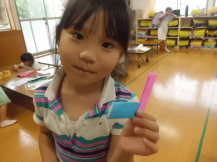 折り紙で作った鉛筆を持つ児童の写真