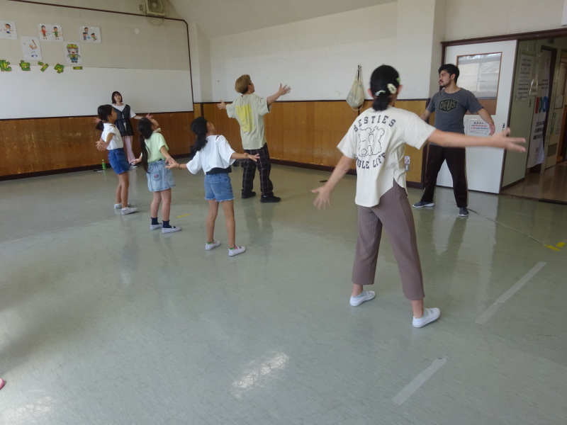 手を広げて踊る子どもたちの写真