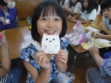 折り紙で作った作品を持つ児童の写真1