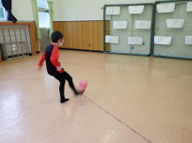 ターゲットに向かってボールを蹴る小学生児童の写真