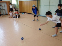 小学生児童が狙いを定めてボールを投げている写真