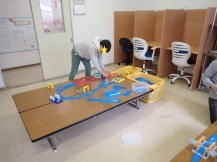 プラレールの組み立てをする中学生の写真
