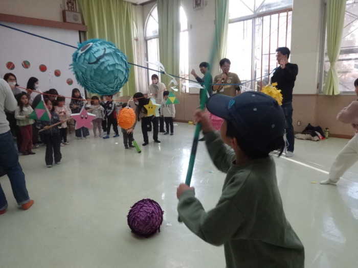 おたのしみ会でのピニャータで遊ぶ小学生の写真