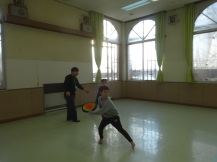 フリスビーを投げる小学生