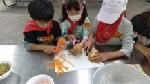 野菜の皮むきをする子どもたちの写真