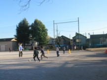 校庭でサッカー遊びをする児童たち
