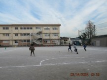 校庭でサッカーをしている児童たち