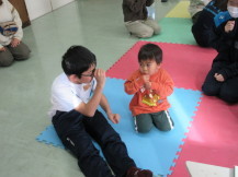 中学生と幼児さんが手遊びをしてふれあう写真