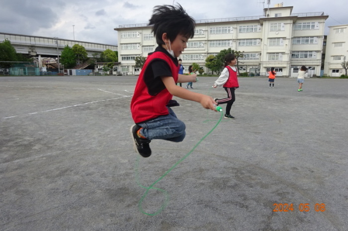 校庭でなわとびをする子どもの写真