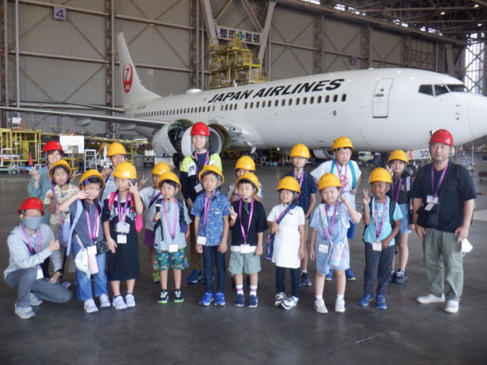 格納庫の中にある飛行機の前で撮った小学生児童と職員の集合写真