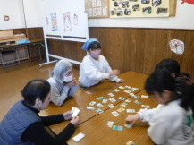 地域の方に読み手をやってもらい、かるたを楽しむ小学生