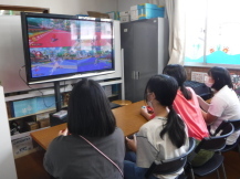 大きなスクリーンでゲームをする子どもたちの写真