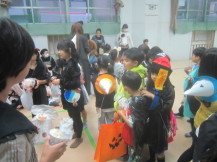 幼稚園でお菓子をもらっている子どもたち