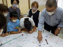 子どもと大人が地域の安全について話し合いをしている写真